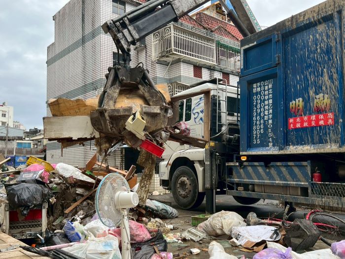 《圖說》運用抓斗車清除南澳民眾排出淹水廢棄家具及廢棄物。〈環保局提供〉