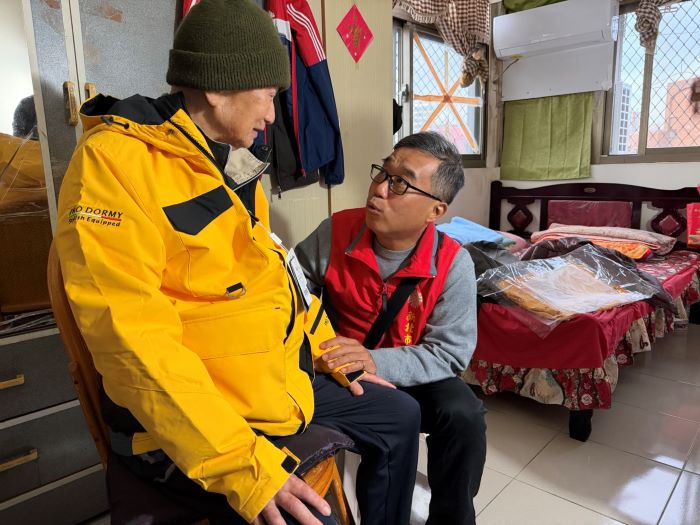 《圖說》李毓錫副處長貼心詢問毛伯伯試穿保暖外套後的感受，並關心日常生活近況。〈新北榮服處提供〉