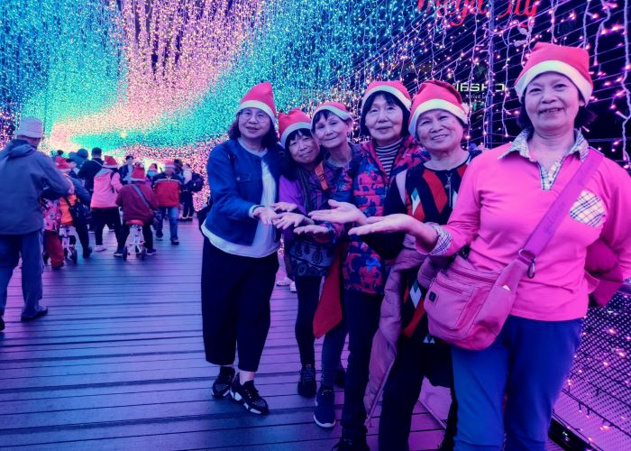 《圖說》新竹縣新埔鎮銀髮寶貝，參訪新北市歡樂耶誕城，大家認為天橋城市光廊最吸睛，紛紛在橋上與燈飾合影。〈觀光局提供〉