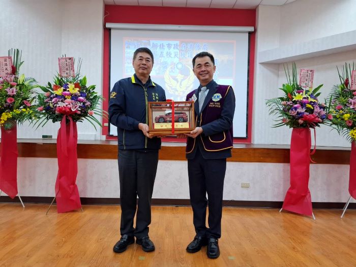 《圖說》消防局回贈消防災勘車模型，左消防局副局長蔡武忠，右家登精密工業公司董事長邱銘乾。〈消防局提供〉