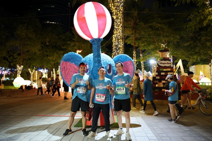 《圖說》2025新北市耶誕馬拉松接力賽，跑者在起跑前與耶誕燈飾合影留念。〈觀旅局提供〉