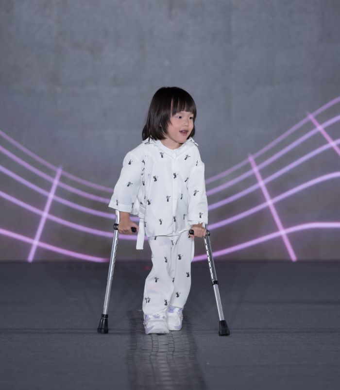 《圖說》罹患腦性麻痺、今年5歲的的簡于涵，拄著前臂拐輔具緩緩登場，感動全場。〈社會局提供〉