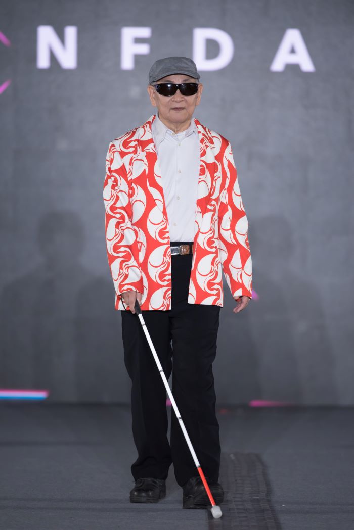 《圖說》七十八歲的視障者許金城，穩健踏上伸展台，展現從容與自信。〈社會局提供〉