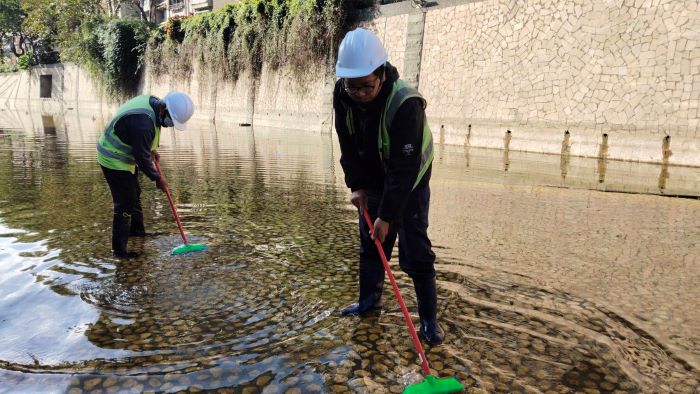 《圖說》現場作業採人工方式進行清洗，以保護底部卵石。〈水利局提供〉