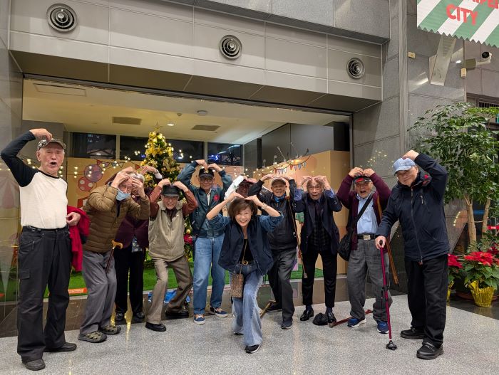 《圖說》板橋榮家長輩們在耶誕燈飾前開心比愛---裡面有三位百歲長輩。〈板橋榮家提供〉