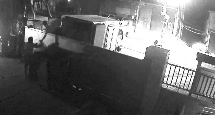 《圖說》兩名非法入侵人員接力丟棄大量廢棄物。〈環保局提供〉