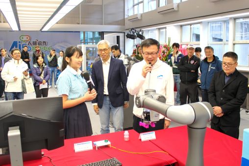 《圖說》三重商工機械科三年級黃盈蓁同學陪同張明文局長進行智慧型機器手臂運作。〈教育局提供〉