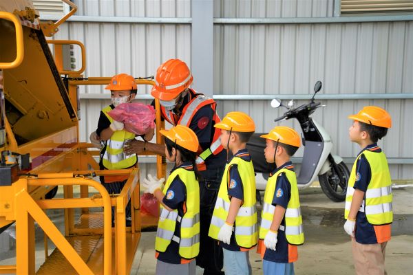 《圖說》小小清潔隊員將垃圾丟入垃圾車，體驗垃圾清運的過程。〈環保局提供〉