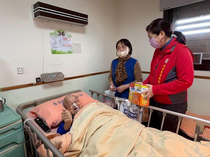 《圖說》吳曉慧總幹事(右)向住院榮民送上春節祝福，陳爺爺(左)欣喜比讚。〈新北榮服處提供〉
