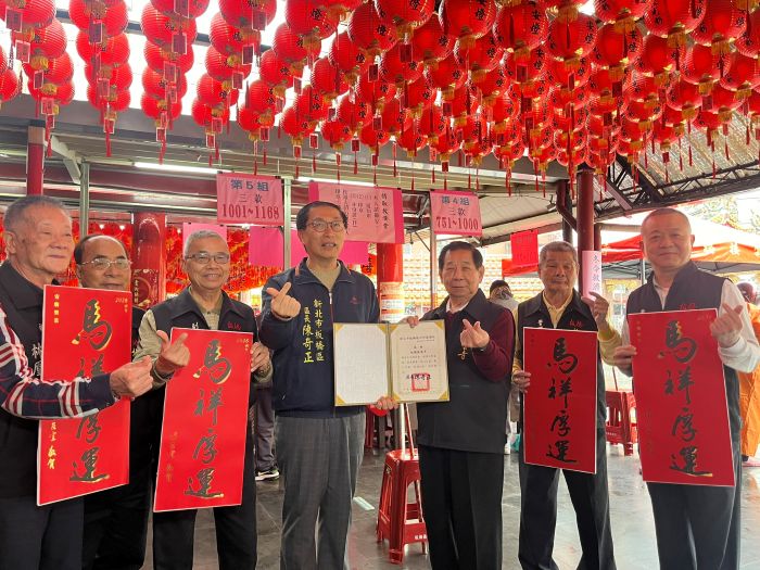 《圖說》陳奇正區長(左4)致贈感謝狀予接雲寺，並宣傳市長馬祥厚運春聯。〈板橋公所提供〉